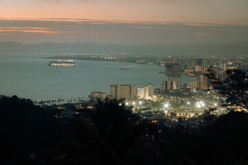 Cruise ship leaving Banderas Bay in Puerto Vallarta Mexico at night seen from high angle view. - obrazy, fototapety, plakaty