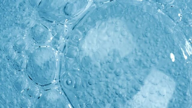 Oxygen bubbles in water on a blue abstract background on super slow motion.
