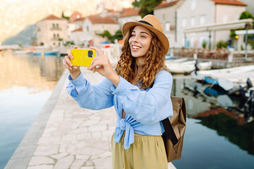 Beautiful female tourist walks the streets and photographed attractions. Lifestyle, travel, rest,...