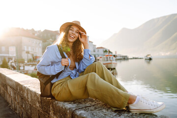 Young female tourist is photographed against the backdrop of attractions.  Lifestyle, travel, rest,...