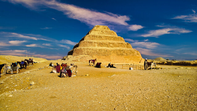 Picture Postcard scenes of camels waiting for tourists in front of the courtyard of the Step Pyramid of Djoser, a masterpiece of ancient egyptian architecture and the first pyramid built 