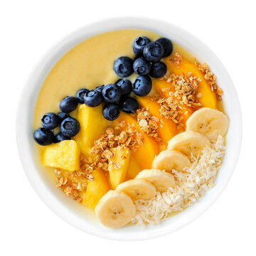 Healthy pineapple, mango smoothie bowl with coconut, bananas, blueberries and granola isolated on a white background