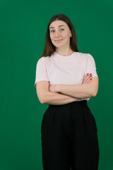 Happy woman smiling with her arms crossed over chest. Joyful emotion. A beautiful Caucasian woman stands on a white background sweater with loose hair. The woman shows emotions.