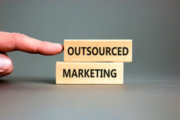 Outsourced marketing symbol. Concept words Outsourced marketing on beautiful wooden blocks....