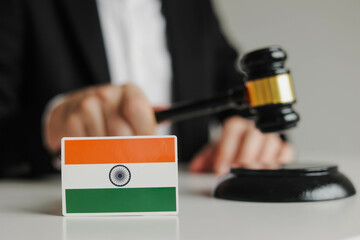 Judge's hand holding wooden gavel. Flag of India. Concept of Indian justice system