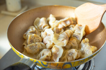 fried dumplings in a pan on stove, Chinese food