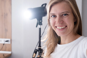 selfie of woman video maker at work, working on content making, using and controlling video light...