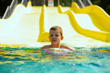 A little boy swimming in a beautiful blue pool with an inflatable circle. Child drowning in the pool	 - 790318116