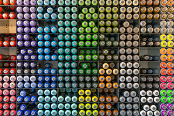 Graffiti spray cans stacked and organized by color in a graffiti street art shop in Amsterdam