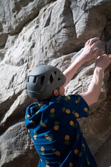 Back of male climber gripping rock