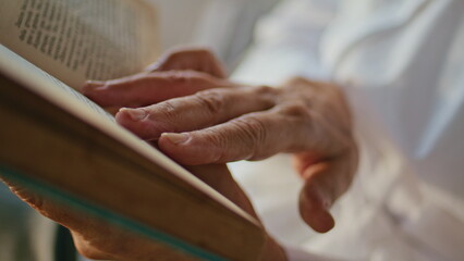 Closeup hands touching book pages running lines. Elderly woman reading novel