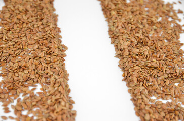 Flax seeds (linseeds) on a white background with an empty space for text, closeup, side view