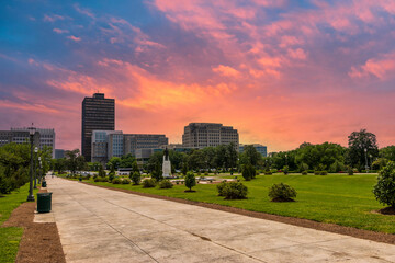 a beautiful spring landscape at Capitol Gardens with lush green trees, plants and grass, colorful flowers and office buildings in the skyline at the Louisiana State Capitol In Baton Rouge Louisiana