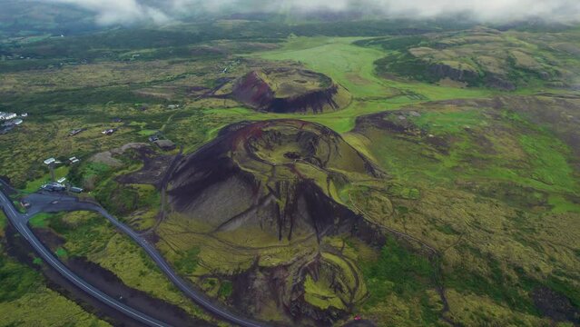 Epic Drone Towards Grabrok Crater Iceland. Lush Green Grass Town Next to Volcano.
