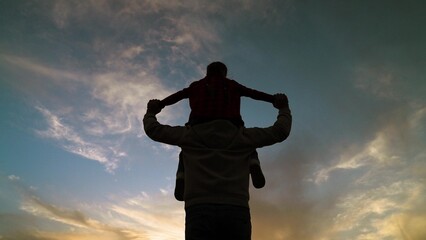happy family child kid baby girl plays on her father shoulders sunset, father child silhouette,...