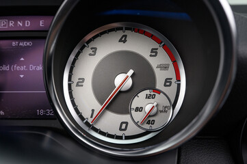 A car dashboard with a tachometer