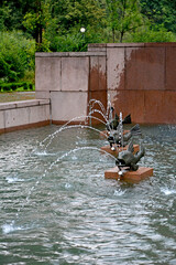 woda tryskajaca z metalowych ryb w fontannie, water gushing from the mouth of metal fish in a...