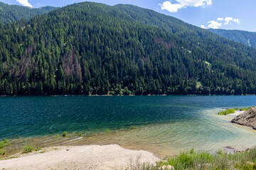 Artificial alpine reservoir lake Zoccolo Zoggler-Stausee and mountain range at Ultental, South Tyrol