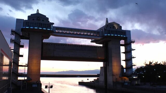NUMAZU, SHIZUOKA, JAPAN - MAR 2024 : View of VIEW-O flood gate at Numazu Port. Gigantic gate designed to protect the city from tsunami. One of the largest water gates in Japan. Sunset time lapse shot.
