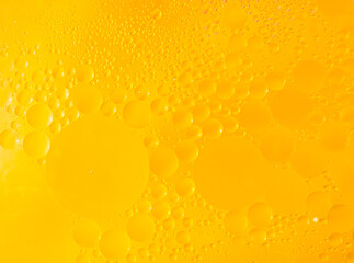 macro photo. Beautiful cosmetic background. Golden yellow abstract oil bubbles or face serum...