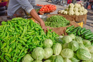 Hand of seller taking different vegetables in street market at Jodhpur
