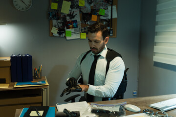 Police detective putting on gloves before examining some evidence in his office