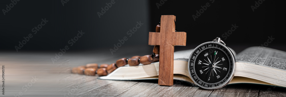 Wall mural open bible on wooden table, compass on it and wooden cross, word of god as guidance concept