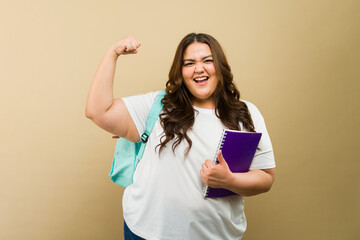 Confident plus-size woman and college student showcases her strength and positivity while holding books - 790416562