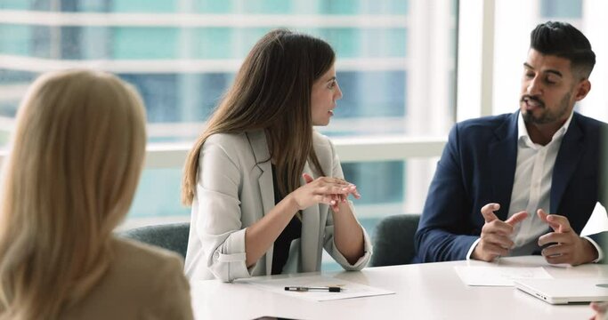 Board of directors gathered together in meeting room listening speech of 30s Latin businesswoman talk about project progress, strategic plans, upcoming company goals, achievements or market analysis