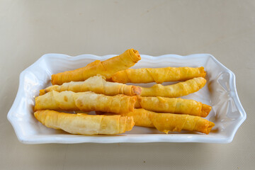 Turkish style meat stuffed filo dough borek served kol boregi. Cheese and minced pie are sliced on a marble background. Turkish name: Kol Boregi, kiymali, peynirli su boregi.. Sigara boregi