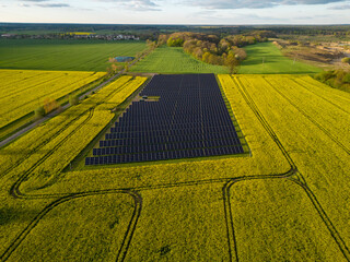 aerial view of solar power plant, environment friendy ecological electricity production on a beautiful farmland field on sunny afternoon