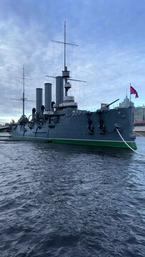 St. PETERSBURG, RUSSIA - April 20, 2024: The Aurora Cruiser Museum on the Neva River on a 20th-century warship. View of the cruiser Aurora, a historical warship, now a war memorial museum. 4К
