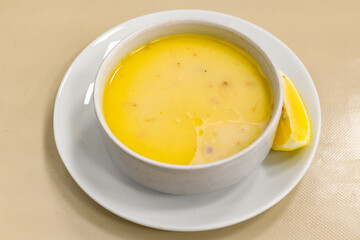 Homemade turkish soup Tavuk Suyu corbasi in a white ceramic soup plate.Turkish noodle chicken broth soup on a plate. Turkish meal (sehriyeli tavuk suyu corbasi)
