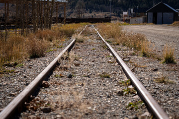 old rail line overgrown with grass in the mountains