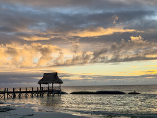 sunrise over a covered dock along the beach