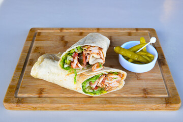 Turkish and Arabic Traditional Ramadan doner kebab with tasty tomato sauce and rice or turkish pilav in white plate on wood table background. ( Pilav ustu doner). Ekmek arasi doner, doner durum. 