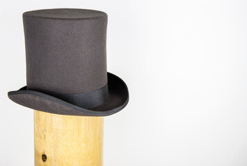 Magic hat. Topper. Elegant vintage gray beige wool felt top hat with black band on the wooden hat...