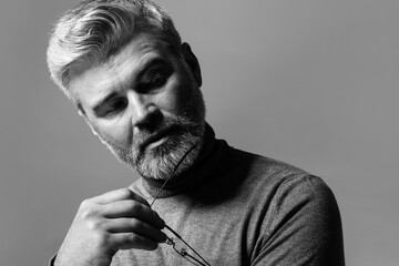 Portrait of handsome man on grey background. Black and white effect