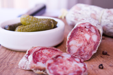 Argentinian salami and pickled cucumbers on wooden cutting board - obrazy, fototapety, plakaty
