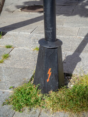 Lightning symbol on the base of a pole. Be careful of electricity. The pole is live.