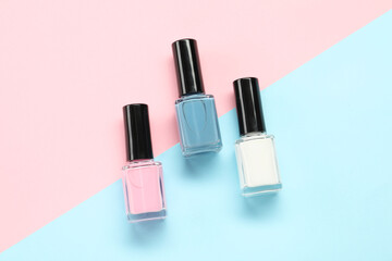 Bright nail polishes in bottles on color background, flat lay