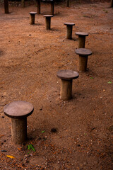 Logs of wood can serve as seats for visitors. Outdoor fitness bar. A Row of Wooden Stepping Stones Across a Grass Field.