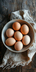Fresh eggs in a bowl on a wooden table,straight top view
