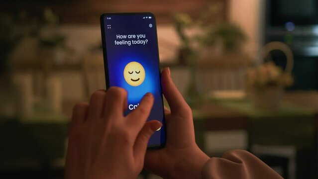 Tracking emotions on a mood tracker app. Choosing a happy emoticon and submitting it to a digital journal.
