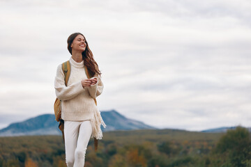 Smiling Woman on Mountain Cliff, Enjoying Adventure and Freedom in Nature