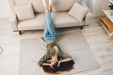 Happy Woman Lying on a Cosy Sofa in a Modern Apartment