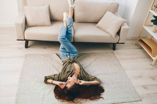 Cozy, Smiling Woman Relaxing on Modern Sofa in Peaceful Apartment