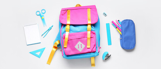 Stylish school backpack with different stationery on grey background