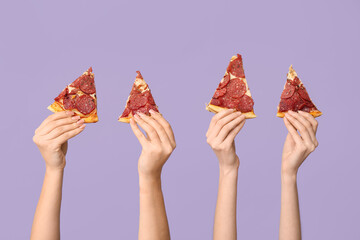 Many hands holding pizza slices on lilac background
