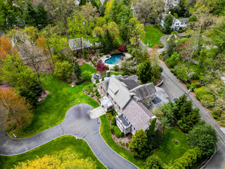 This drone-captured image offers a stunning overview of a prosperous neighborhood in Millburn, NJ,...